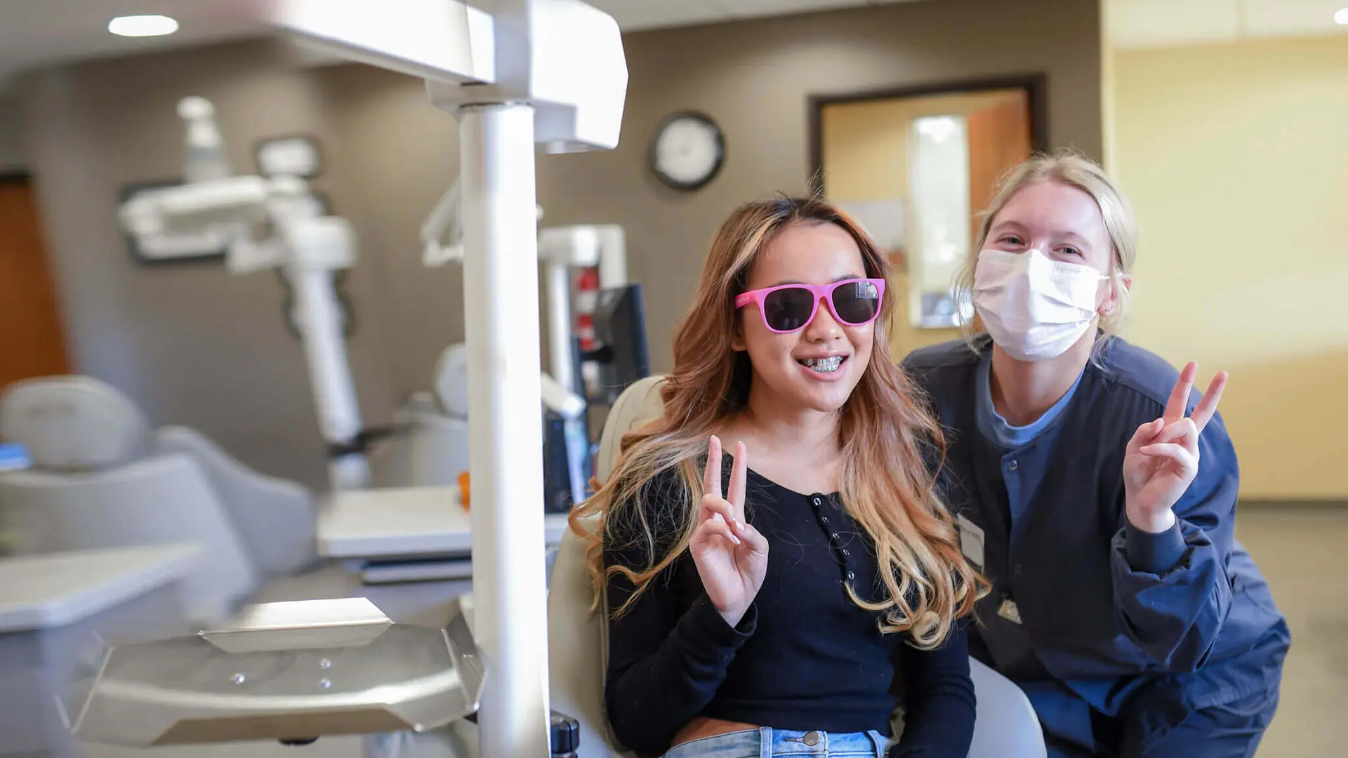 young patient with team member throwing peace signs