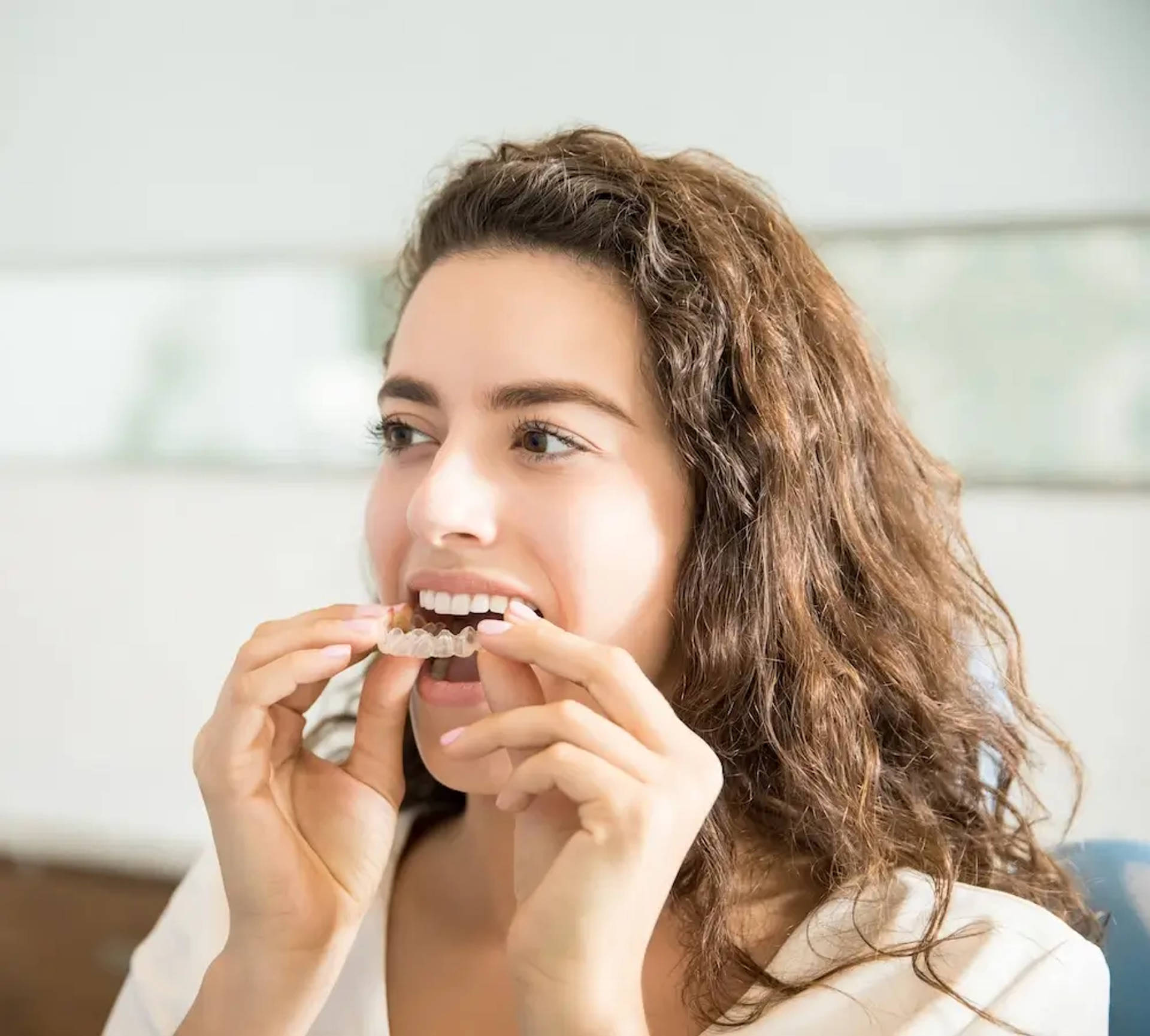 woman putting on aligners