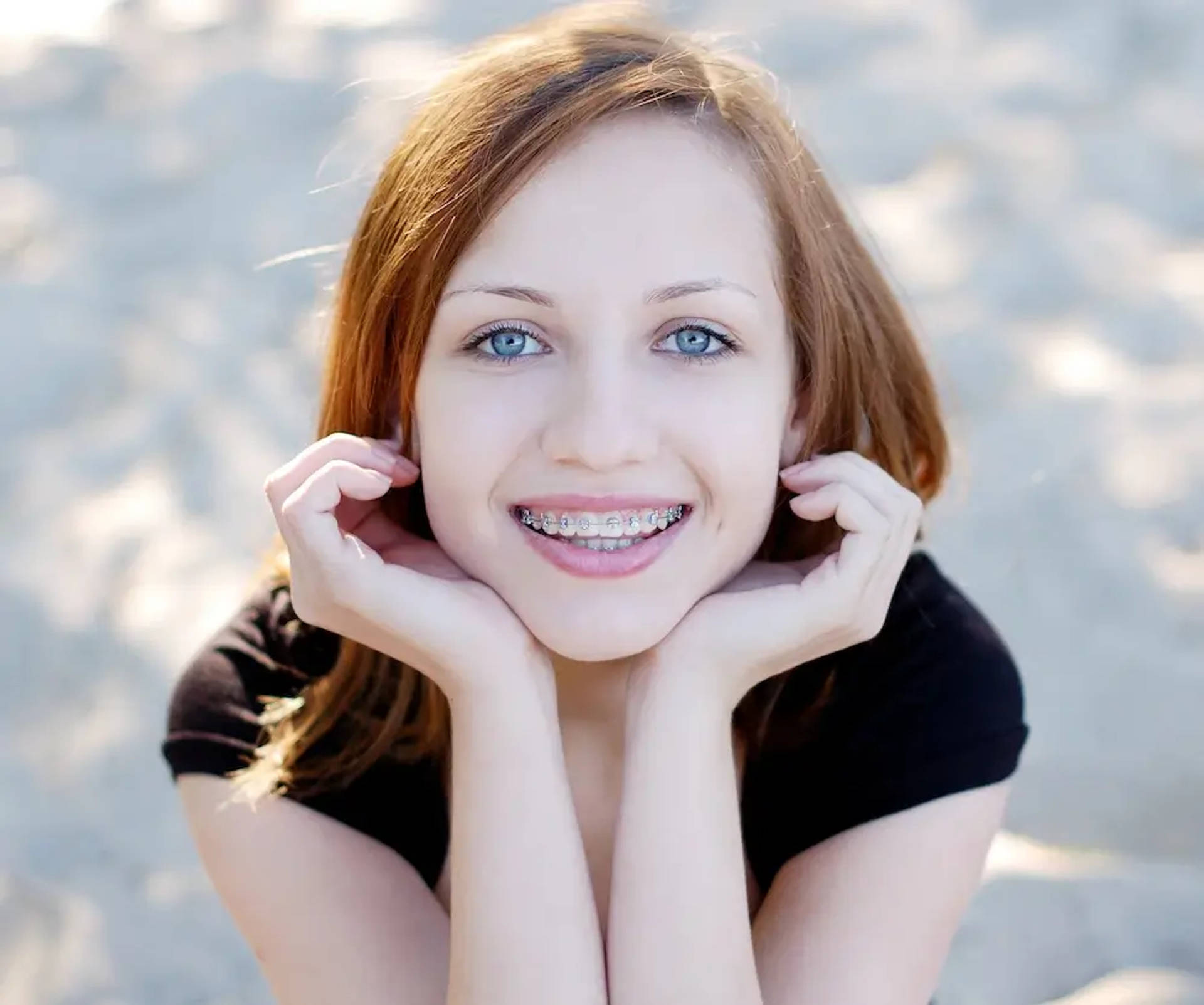 smiling young woman with braces at beach