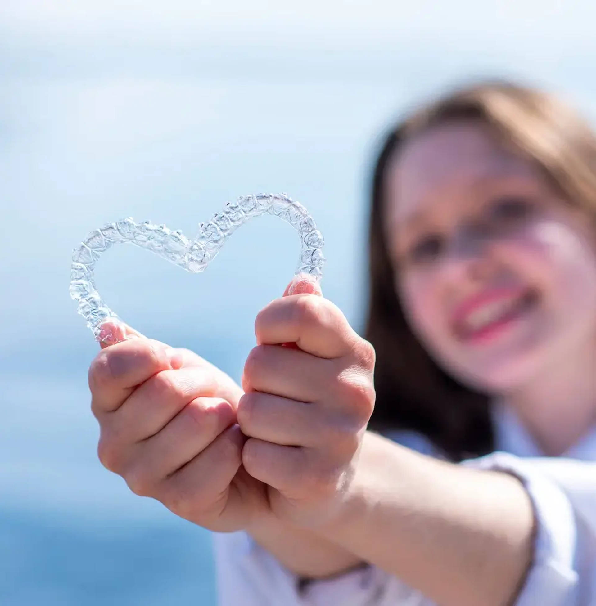 woman holding retainers in shape of heart