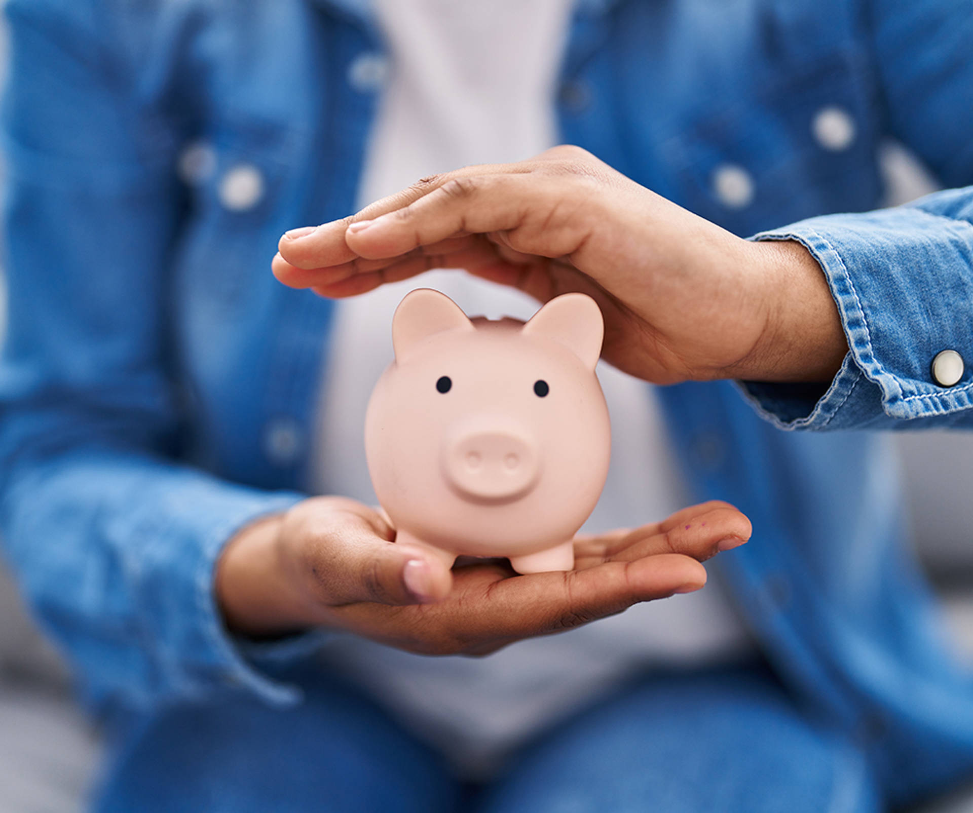 two hands holding a piggy bank