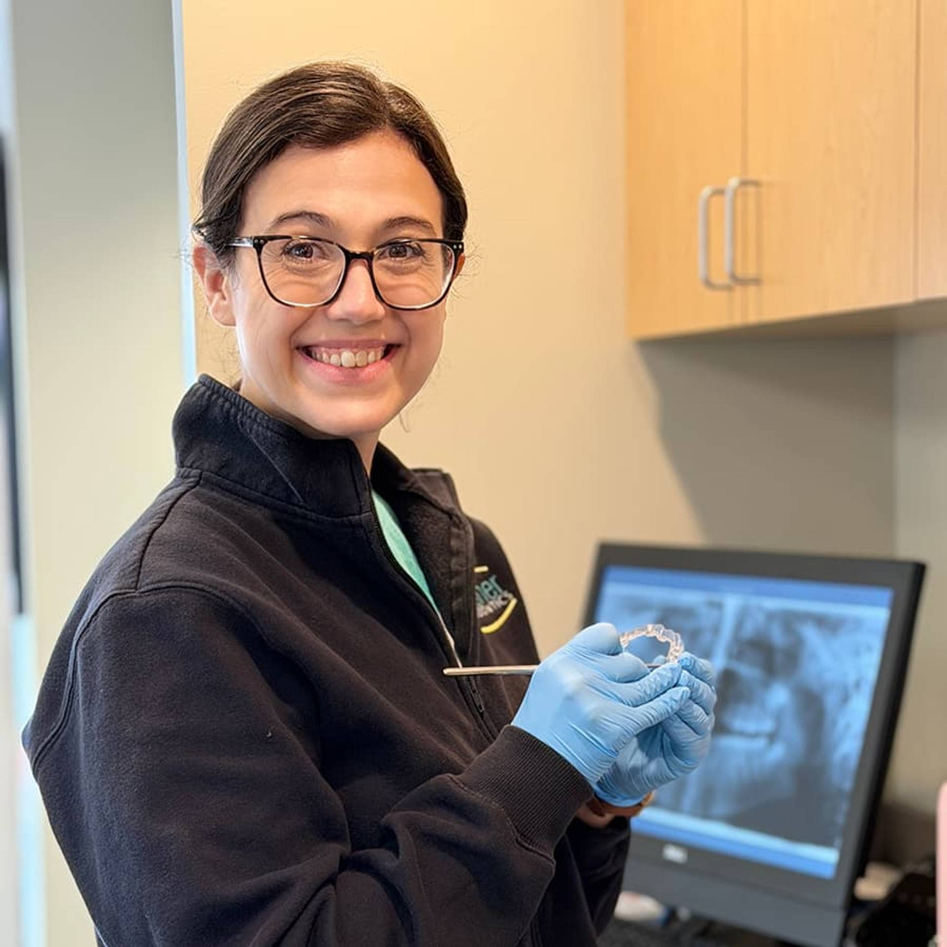 team member holding clear aligner