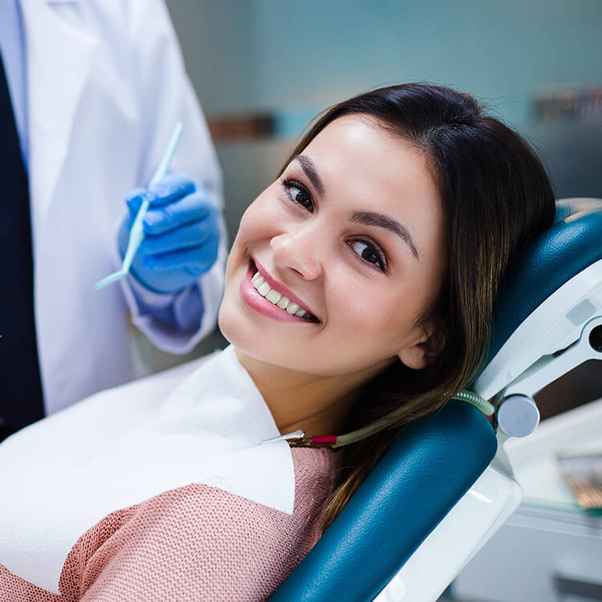 Her amazing smile! Beautiful young woman looking at camera with smile in dentist’s office