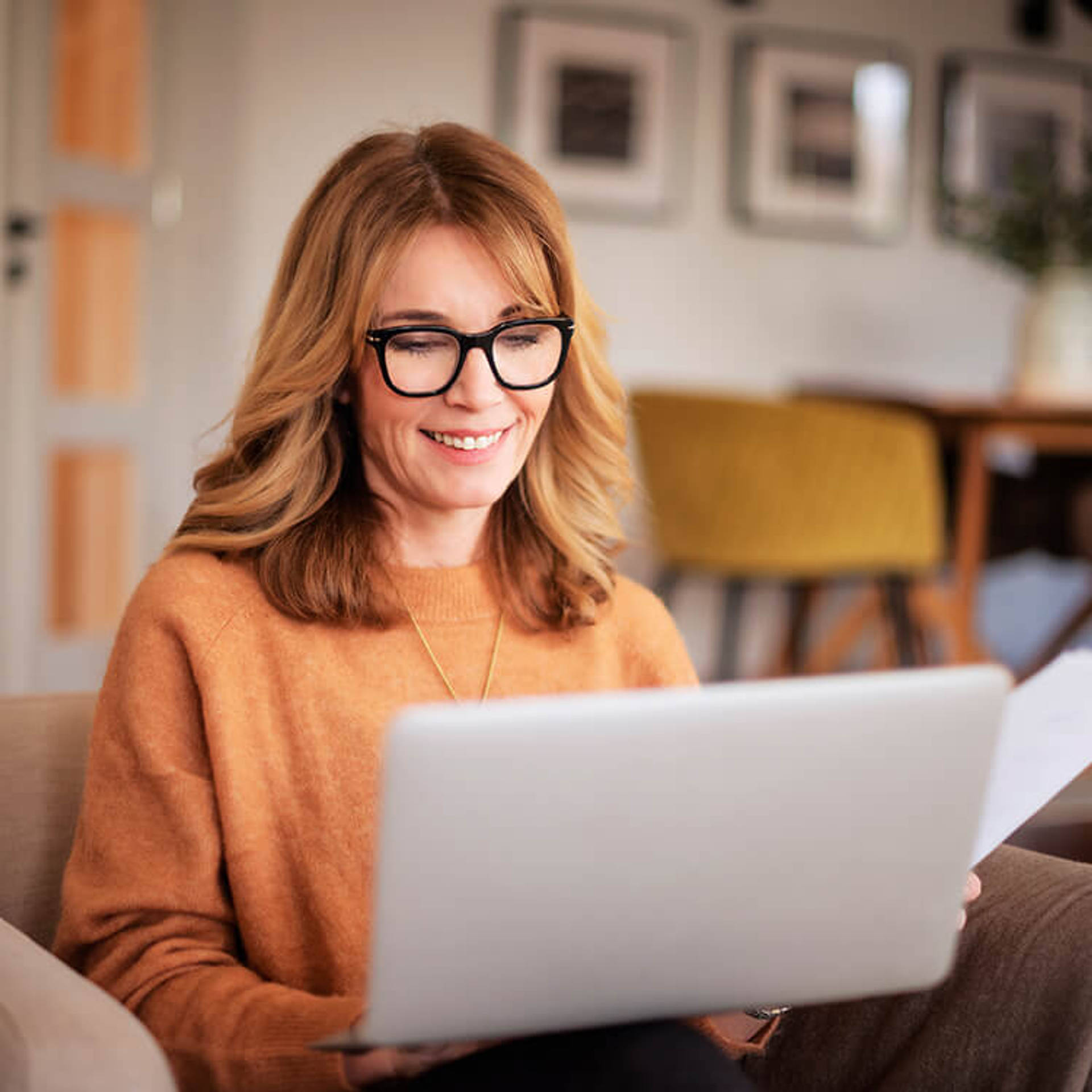 Attractive woman sitting at home and using laptop for work