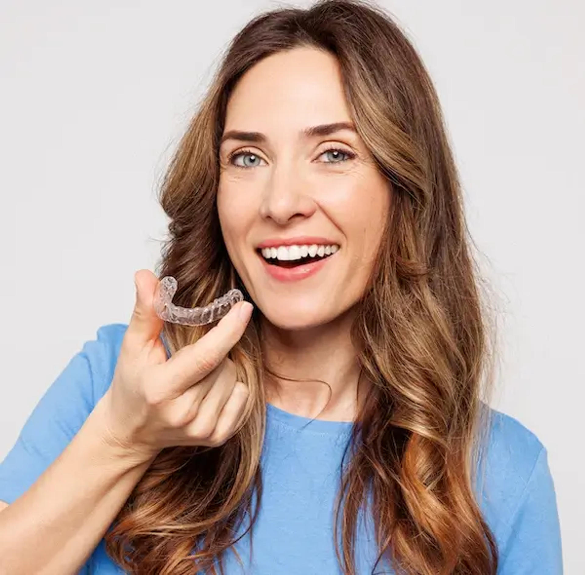 smiling woman holding retainers