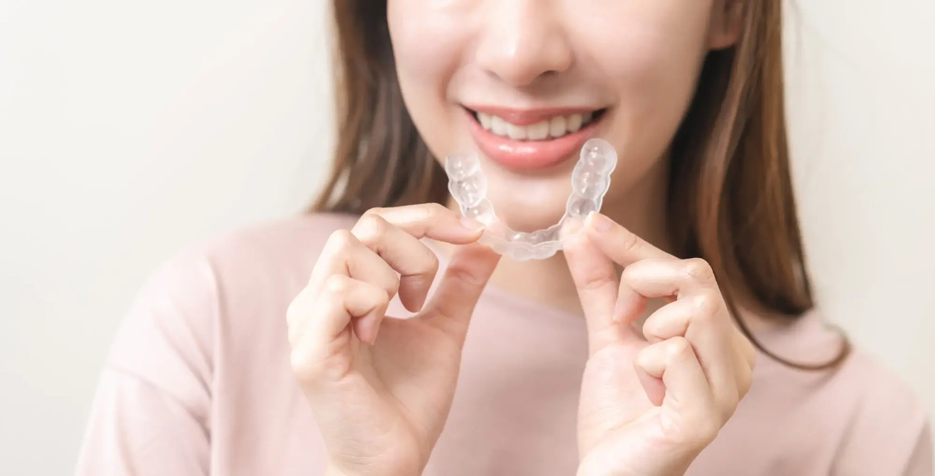 smiling woman putting on clear aligners