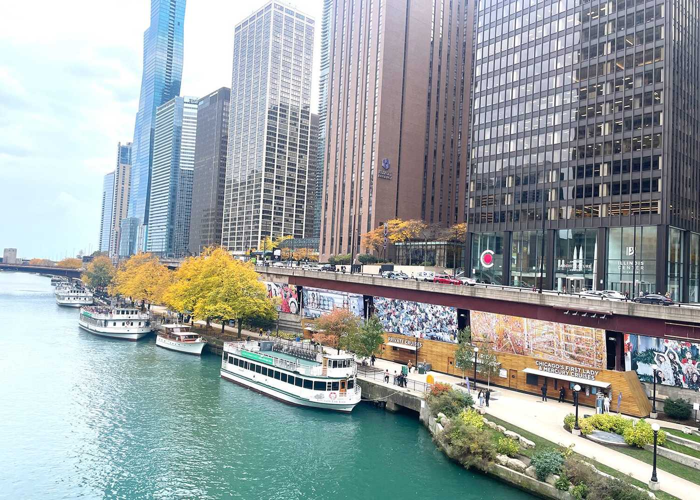 Boats in the river with skyscrapers on the side of the river