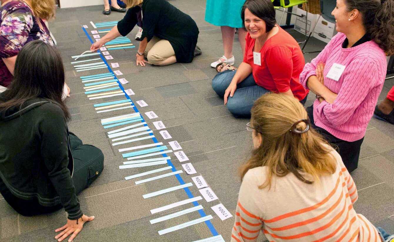 a group of educators lining pieces of paper on the floor