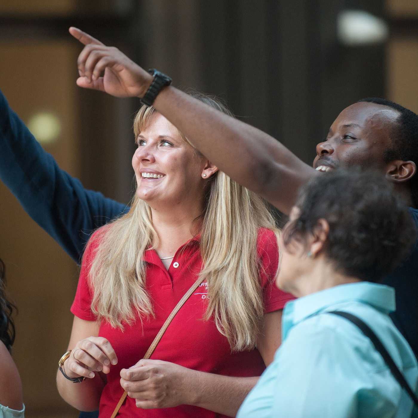 A group of people outside. The center figure is a blond woman in a red CAC polo shirt. Photo courtesy of CAC/ Anna Munzesheimer