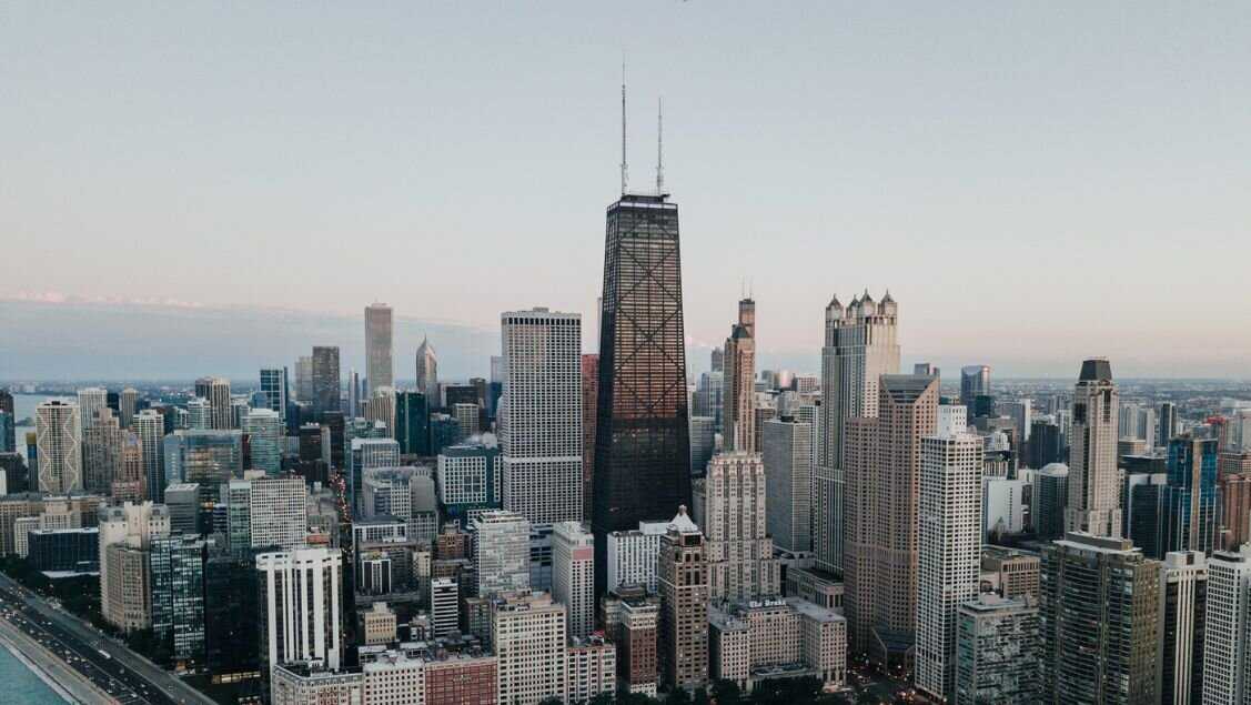 A skyline image of 875. North Michigan Avenue at the center surrounded by other Chicago buildings