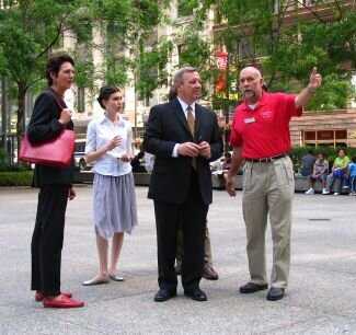 Image of 4 Figures standing on a city plaza