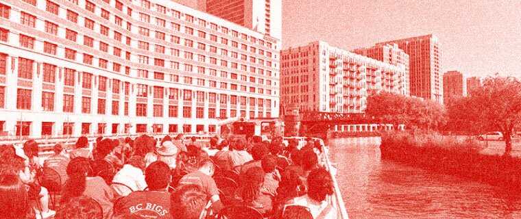 A group on a boat tour with the merchandise mart in the background. The photo has a red overlay