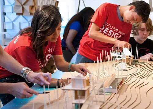 Students in red t-shirts working on a building model