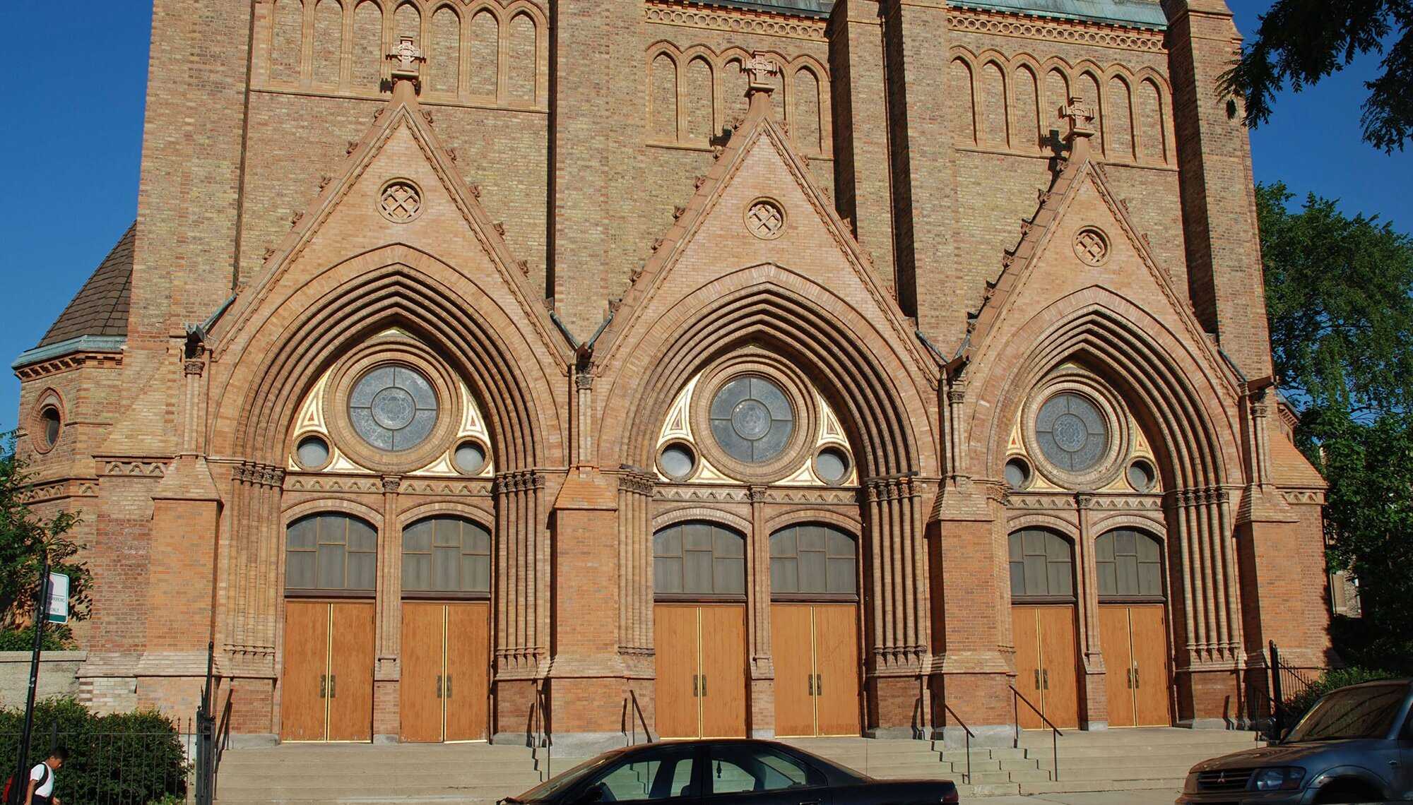 Exterior of gothic church with 3 arches and 6 doorways