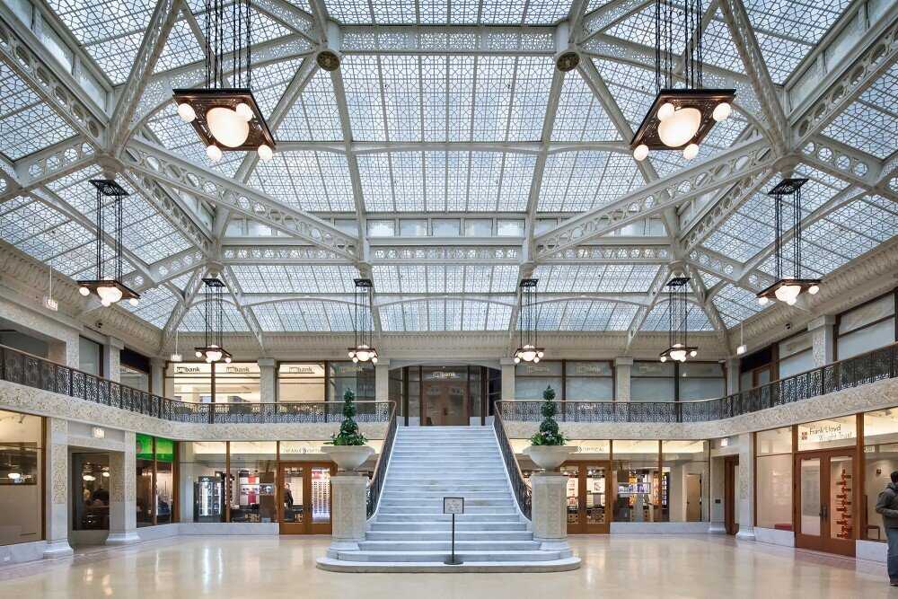 Interior view of the Rookery Building in Chicago, featuring a grand atrium with ornate ironwork, marble floors, and natural light.