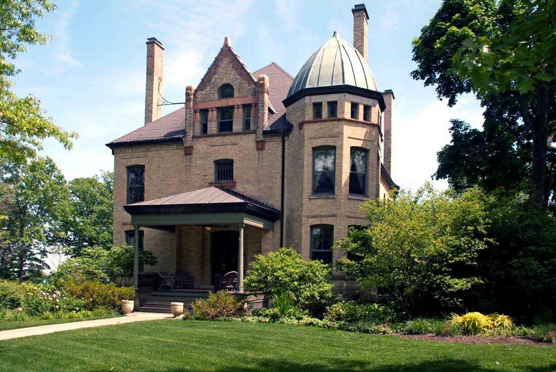 Exterior view of brick building with turret and two chimneys