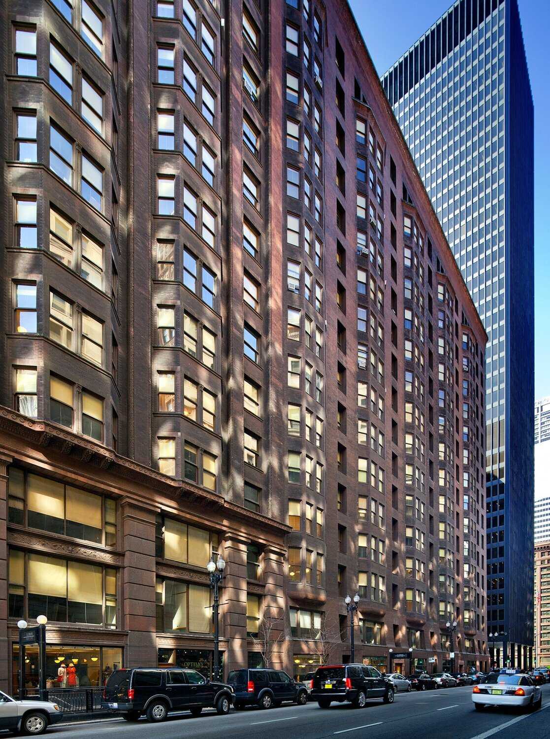 Exterior of brown stone building with bay windows