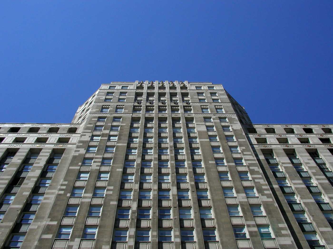 Exterior of large white building, looking up from the ground