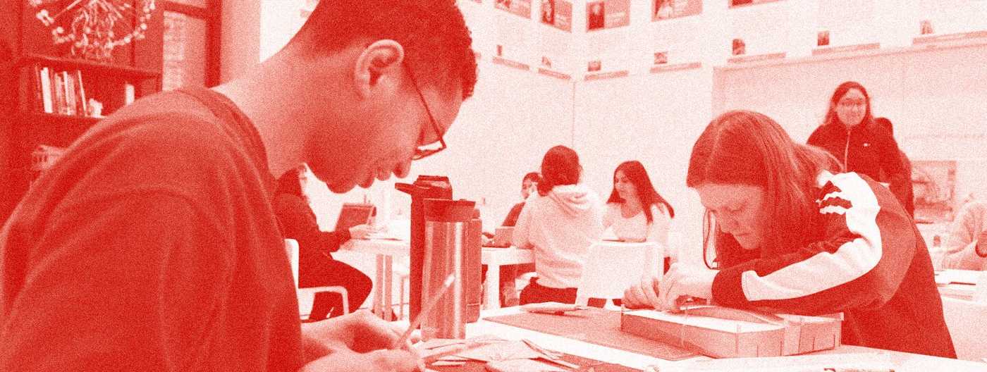 Two teens working on a building model with red overlay