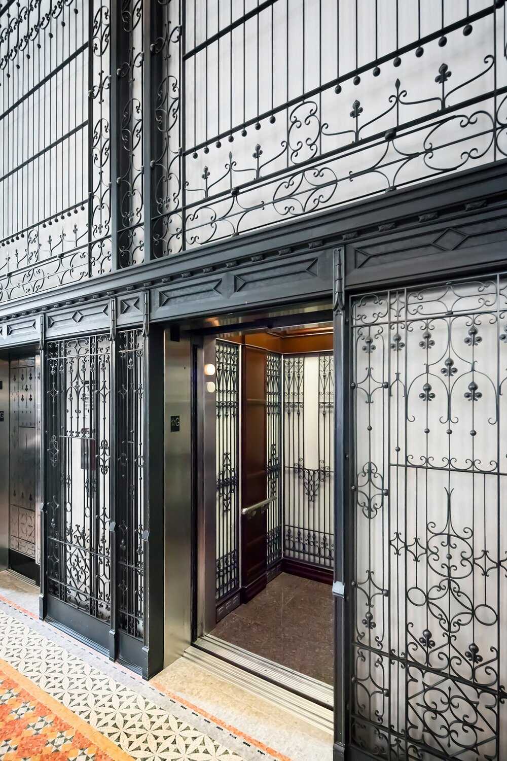 Elevators inside building with ornate black detail