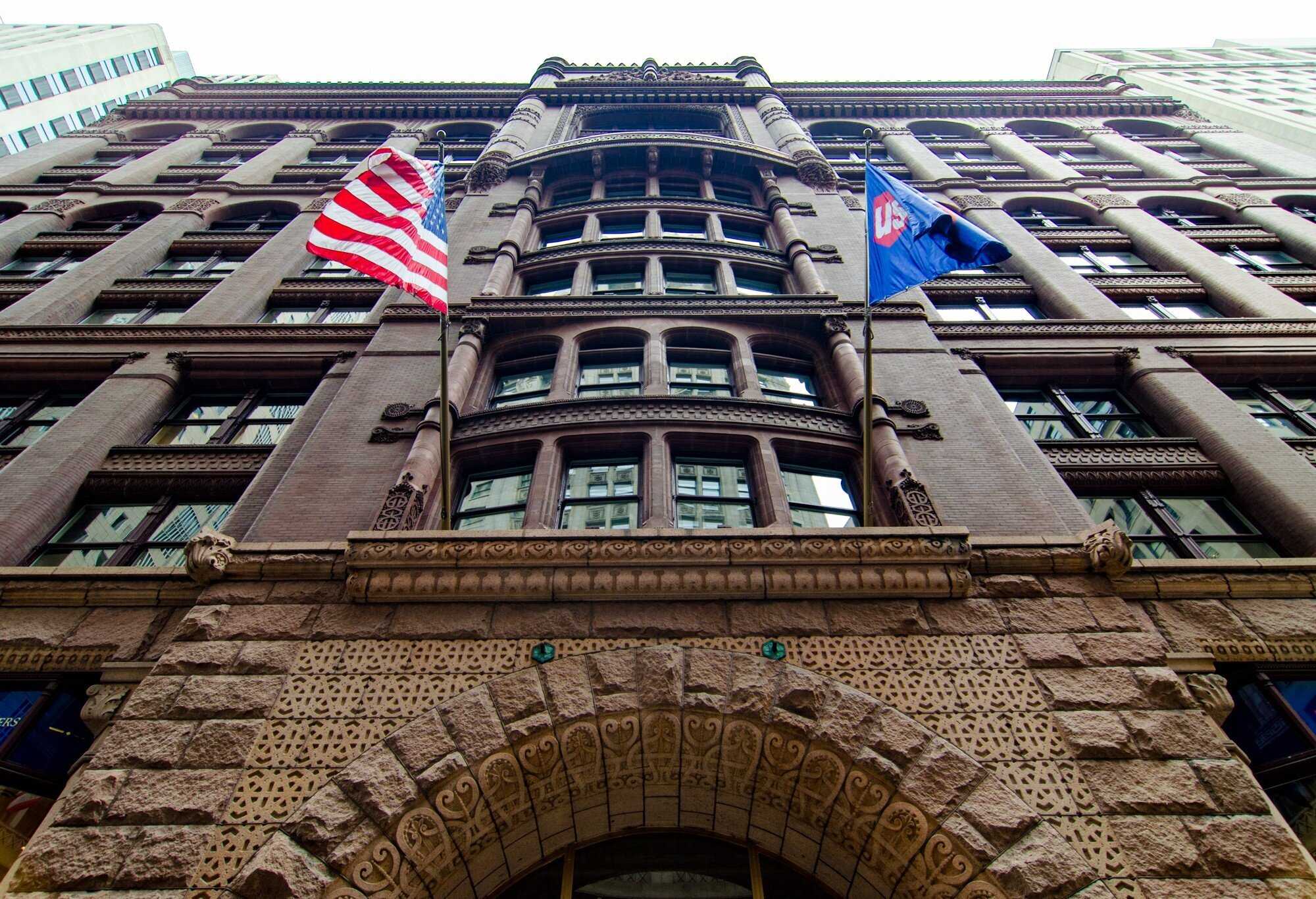 Looking up at entrance to building with two flags