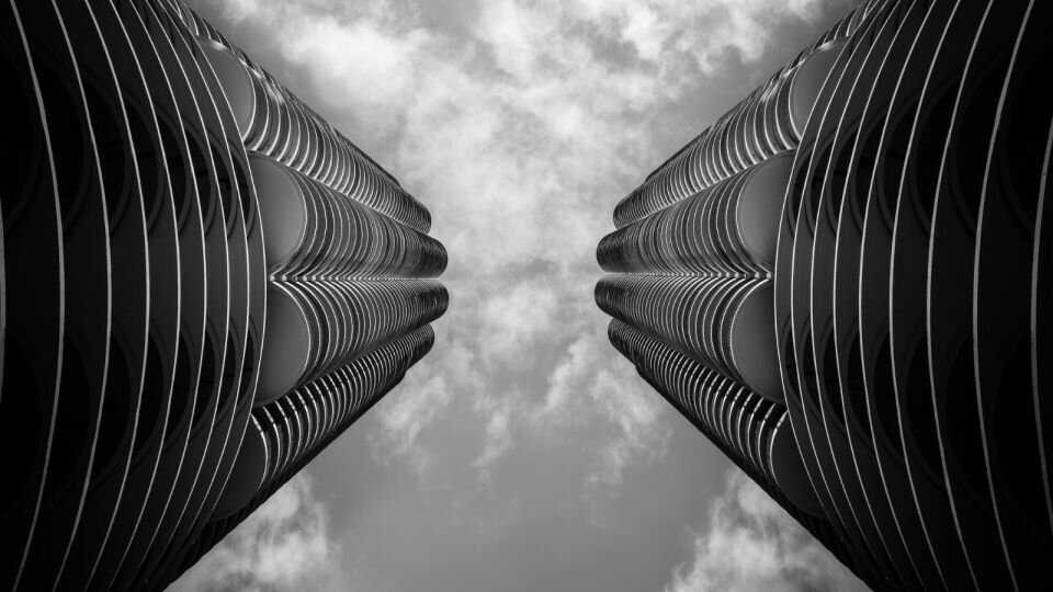 Black and white shot of looking up at two skyscrapers