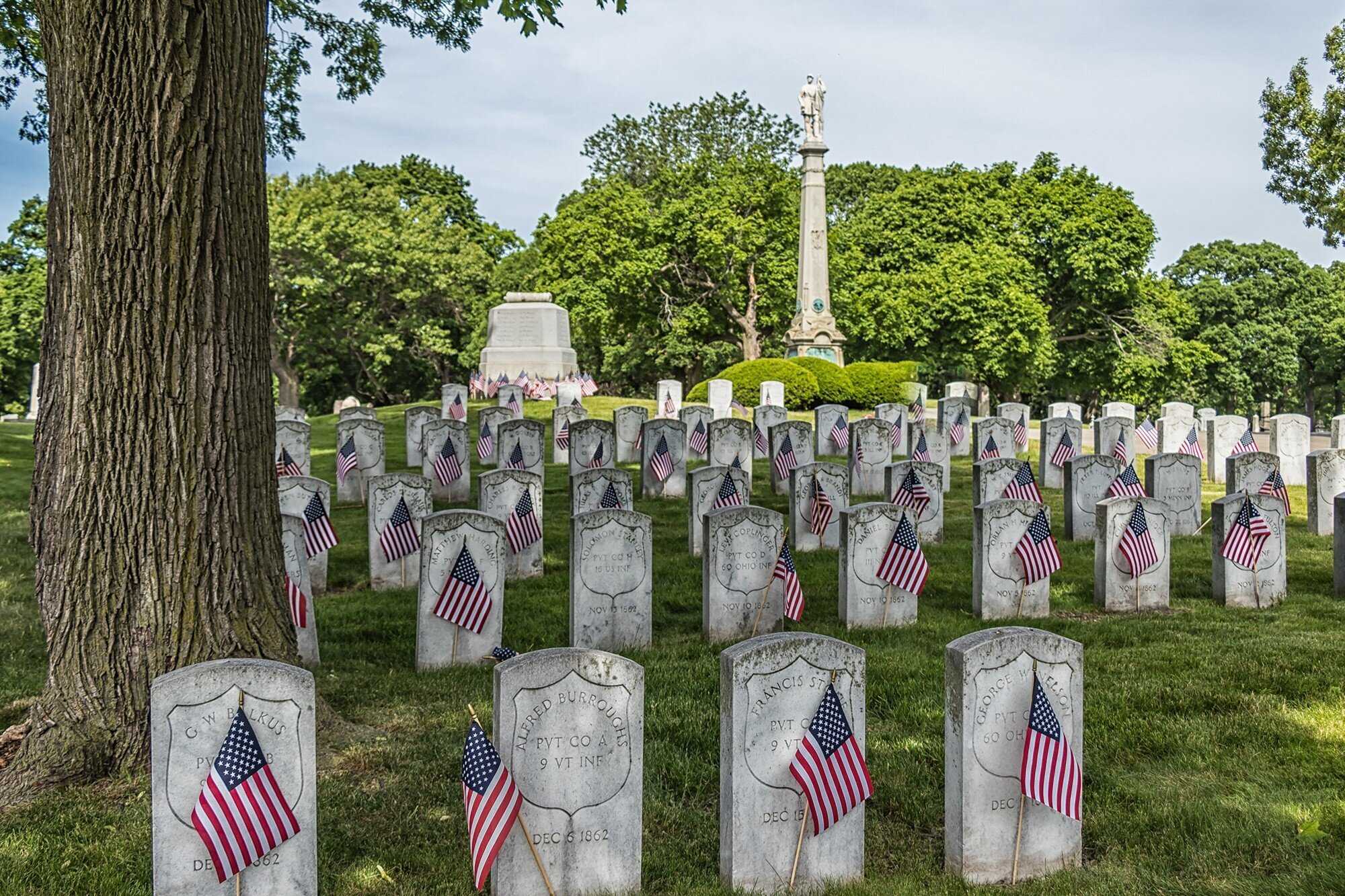 A photo of the Civil War Memorial with headstones adorned with American flags.