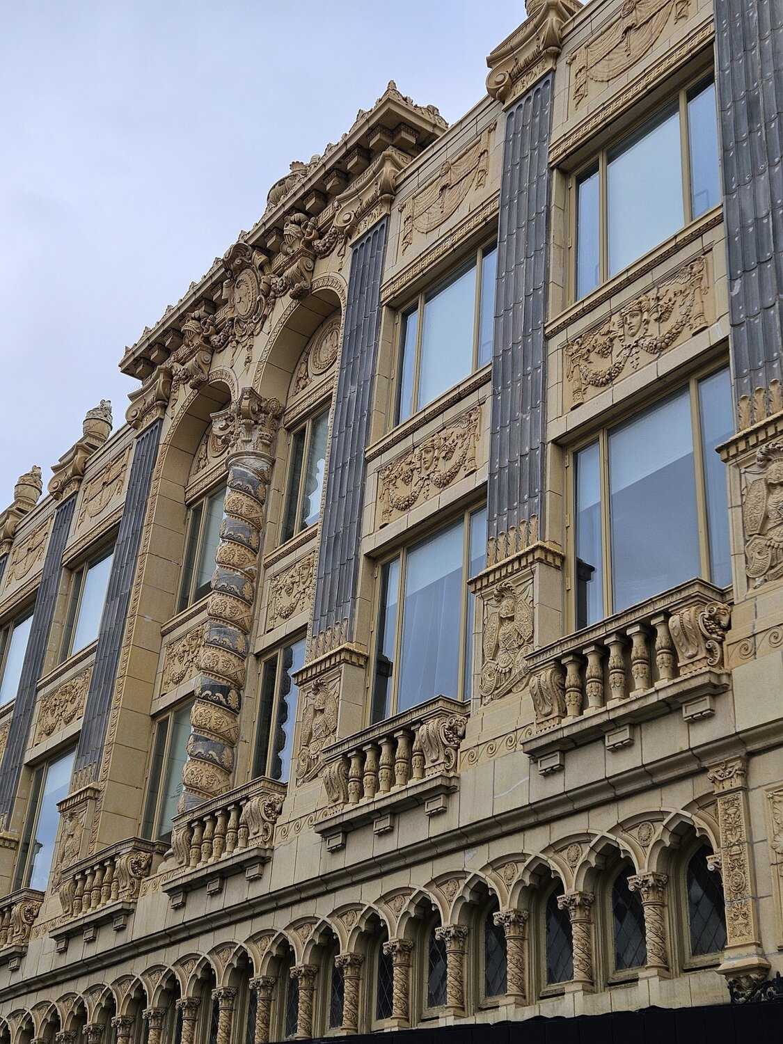 3 story terra cotta building with arched windows