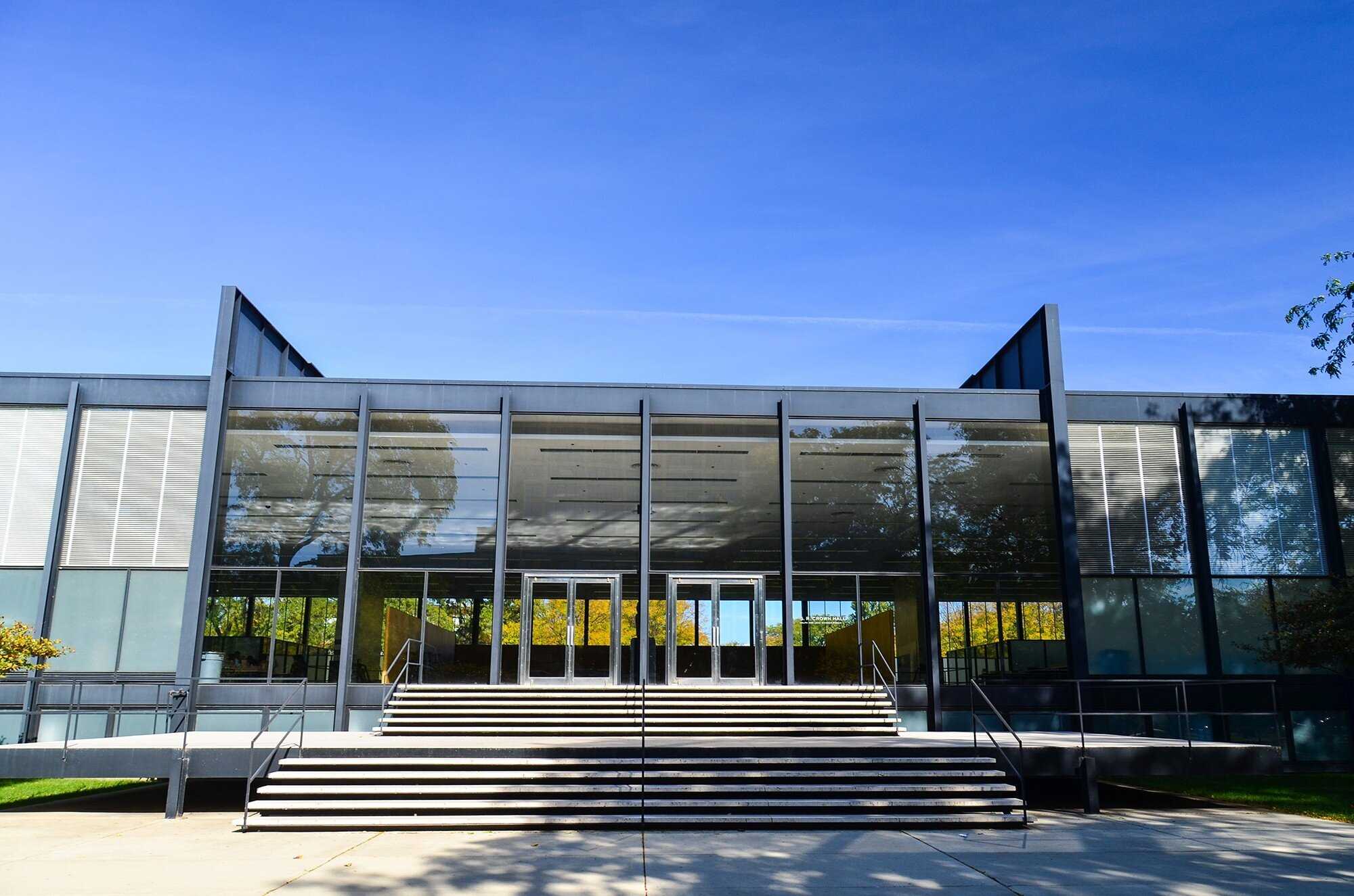 Crown Hall, iconic modernist architecture by Mies van der Rohe, featuring a minimalist design with steel framing and glass walls.