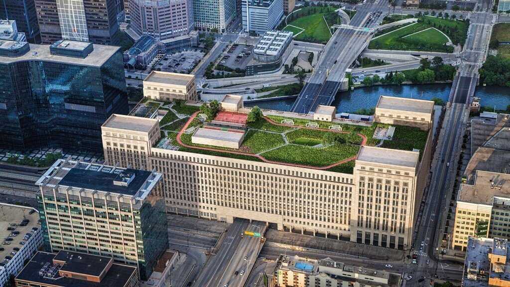 aerial view of building roof with green space and a red track