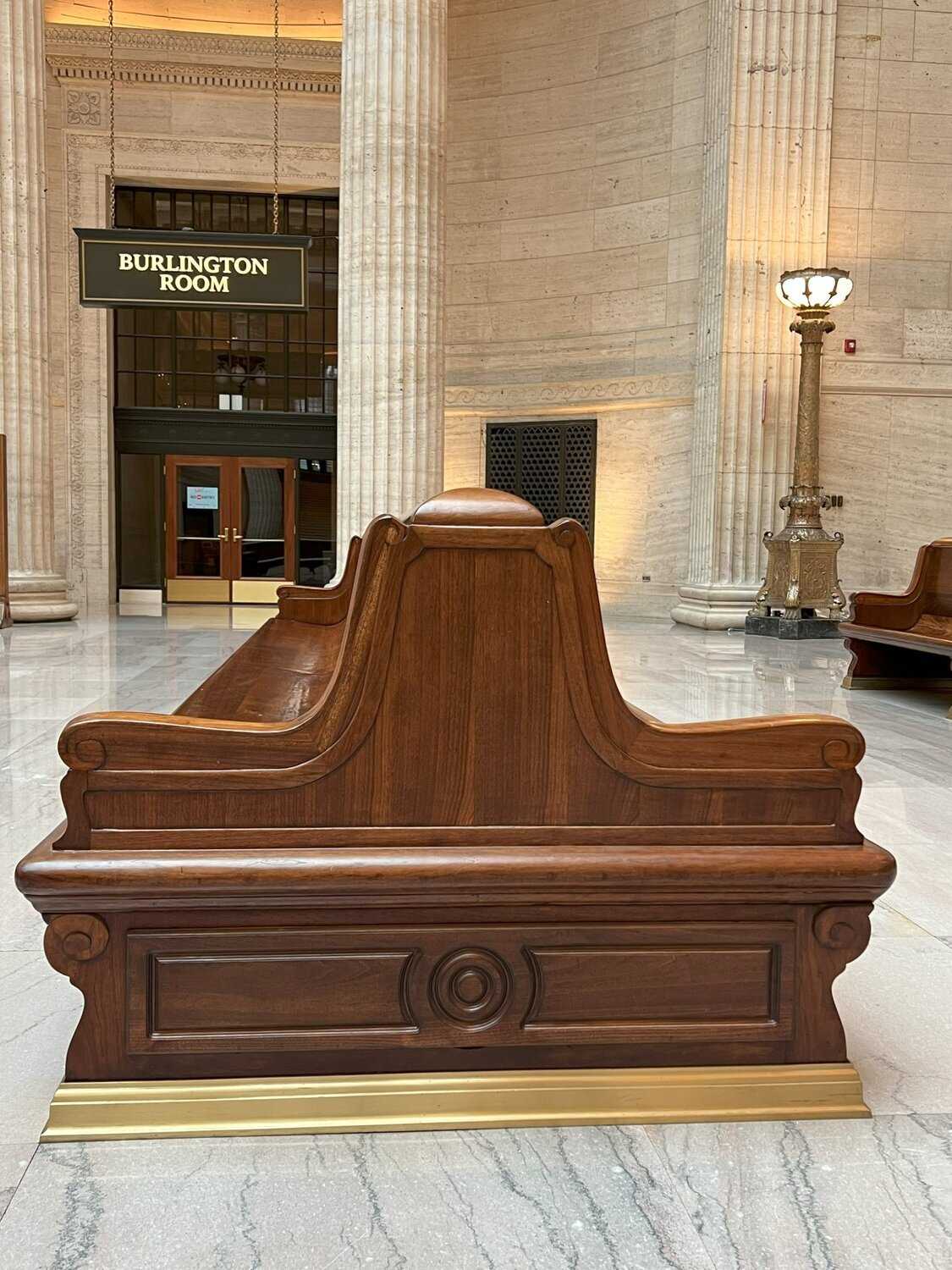 Photo of a wooden bench with side carvings inside union station