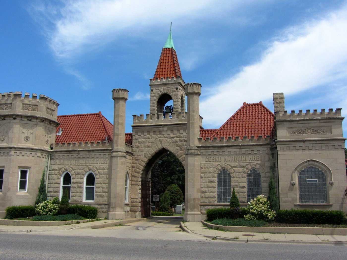 A photo of stone building with a bell tower in the center.