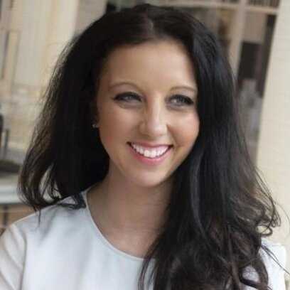 Smiling woman with long brown hair in white shirt