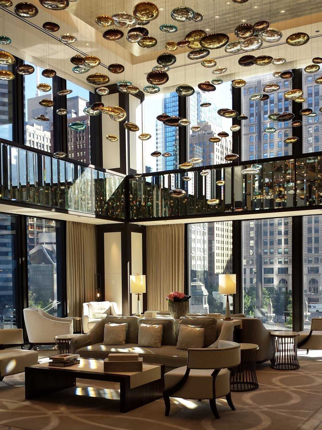 An interior photo of the The Langham Hotel featuring an art installation hung from the ceiling.