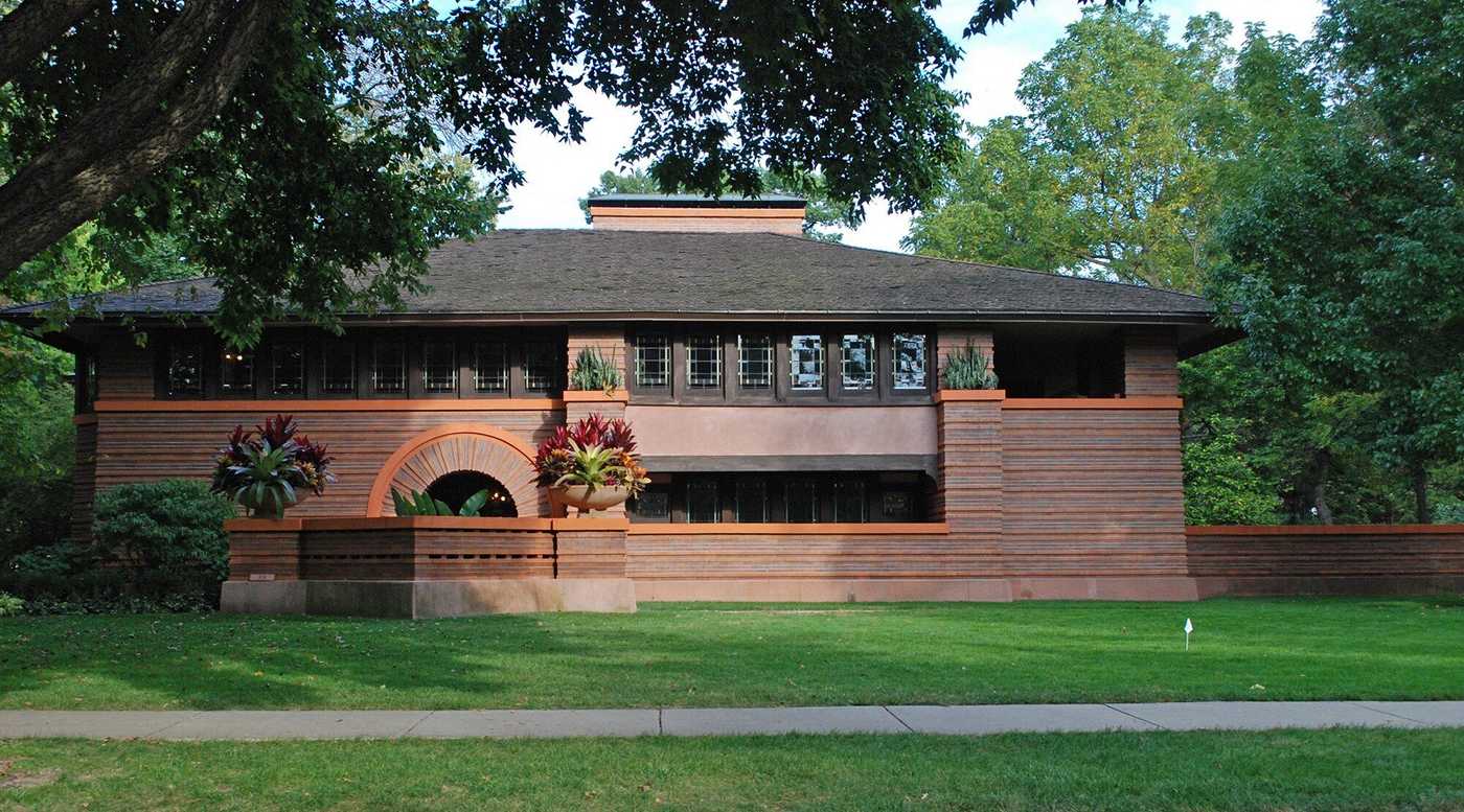 Exterior view of the Frank Lloyd Wright-designed Heurtley House, featuring Prairie School architecture with horizontal lines, a low-pitched roof, and large windows.