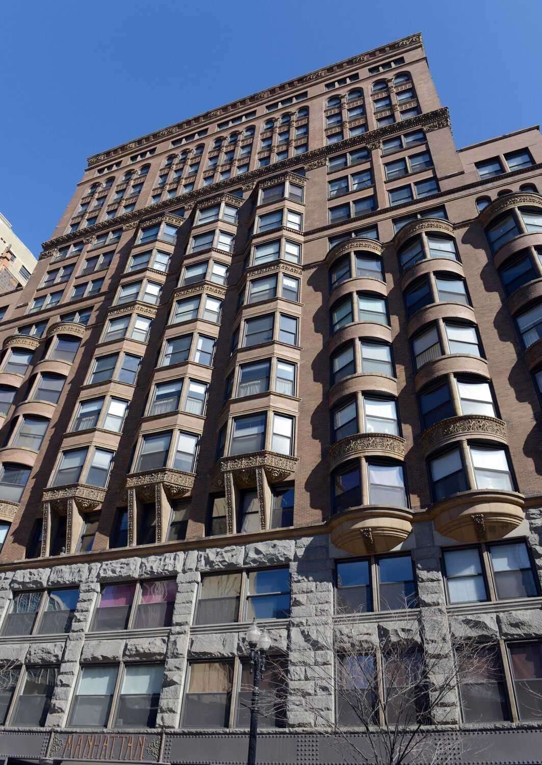 Exterior of brown stone building with bay windows