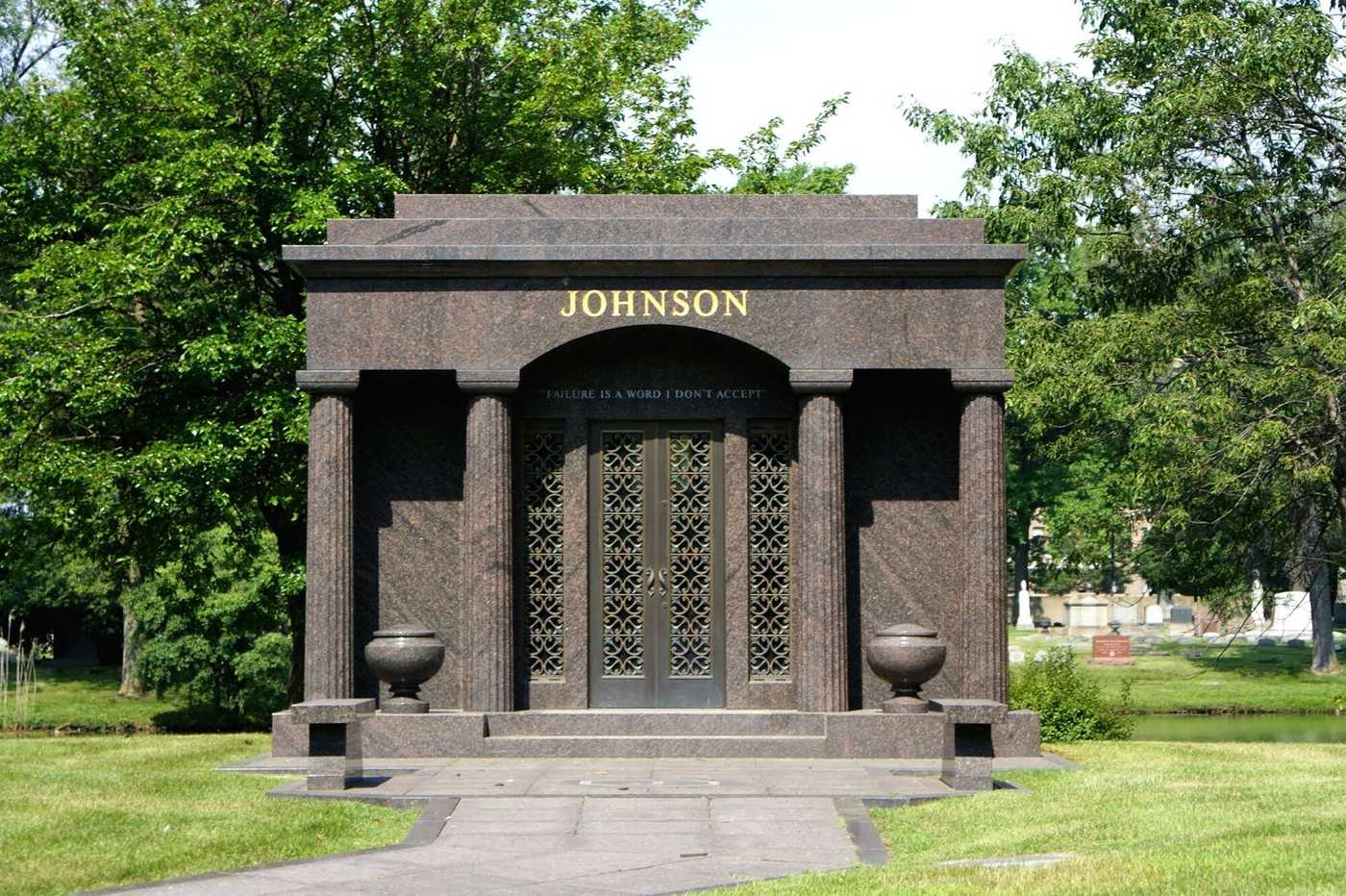 Large dark brown crypt with 4 columns and 2 urns.  