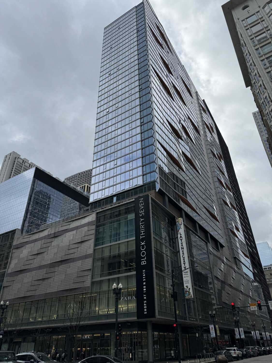 Tall slim black building covered in glass