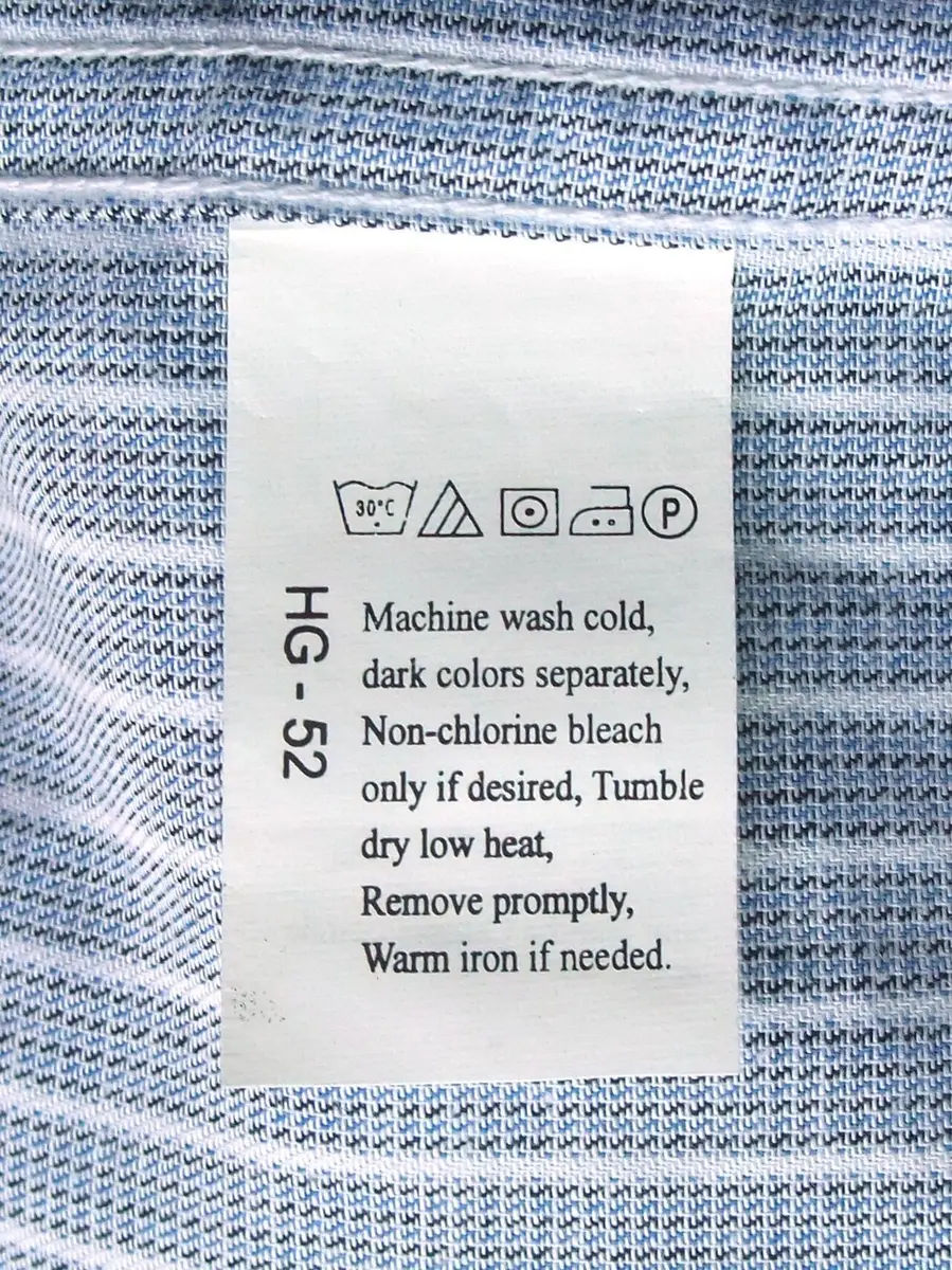Étiquette d’entretien cousue sur un tissu avec les symboles de lavage, de séchage et de repassage