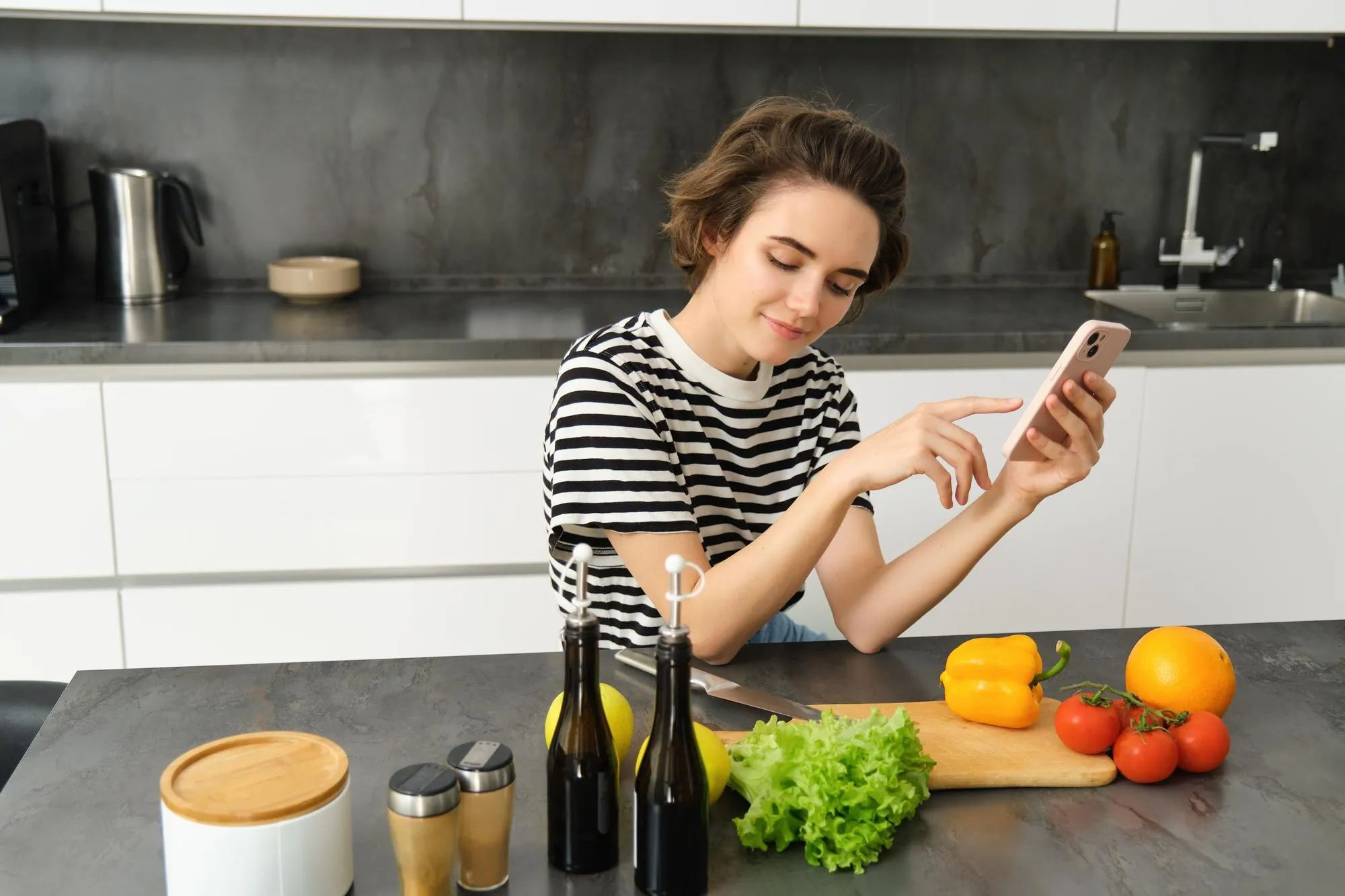 Home cook using a phone while preparing ingredients