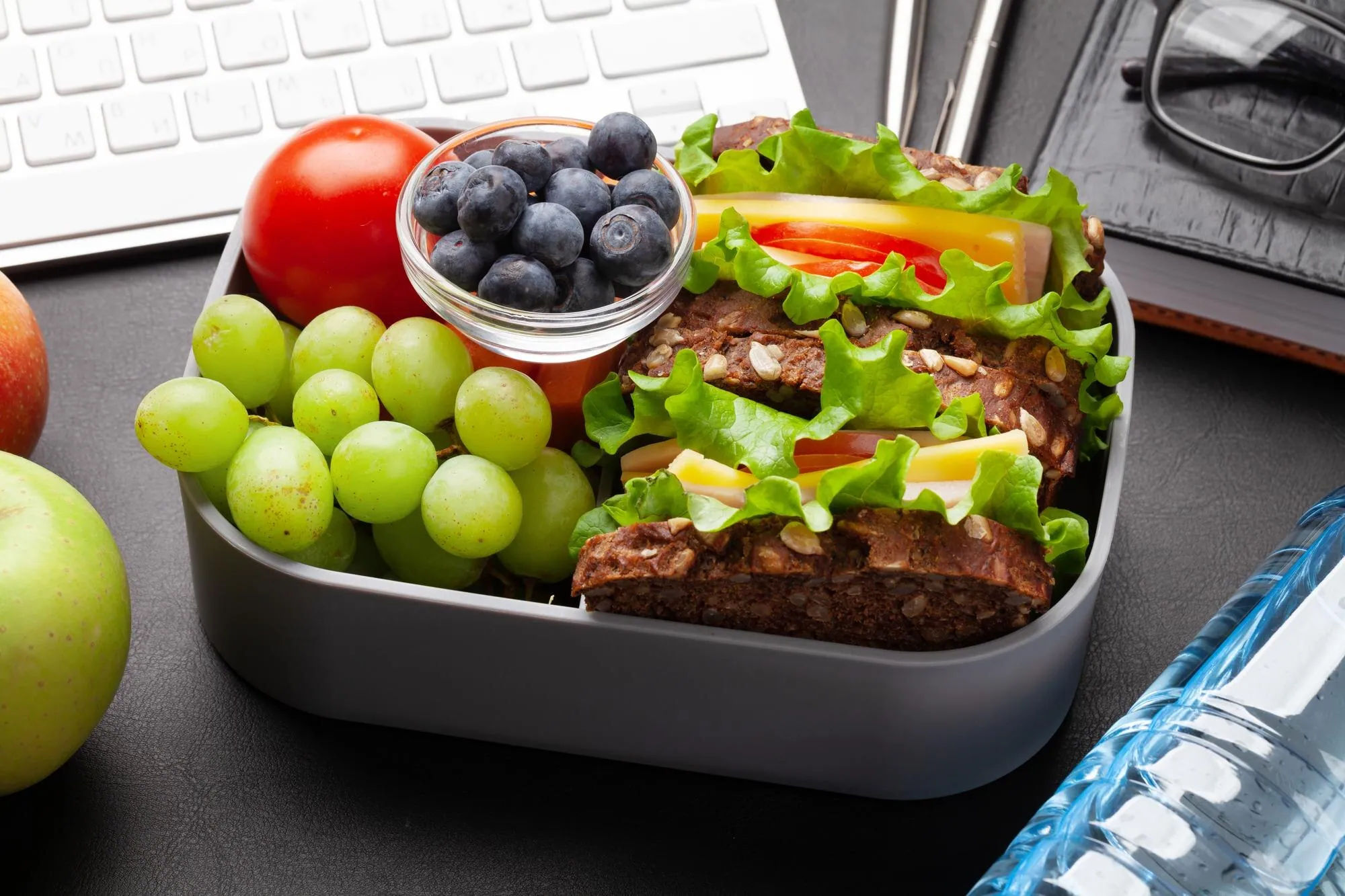 Lunch box da ufficio con sandwich, frutta e verdure
