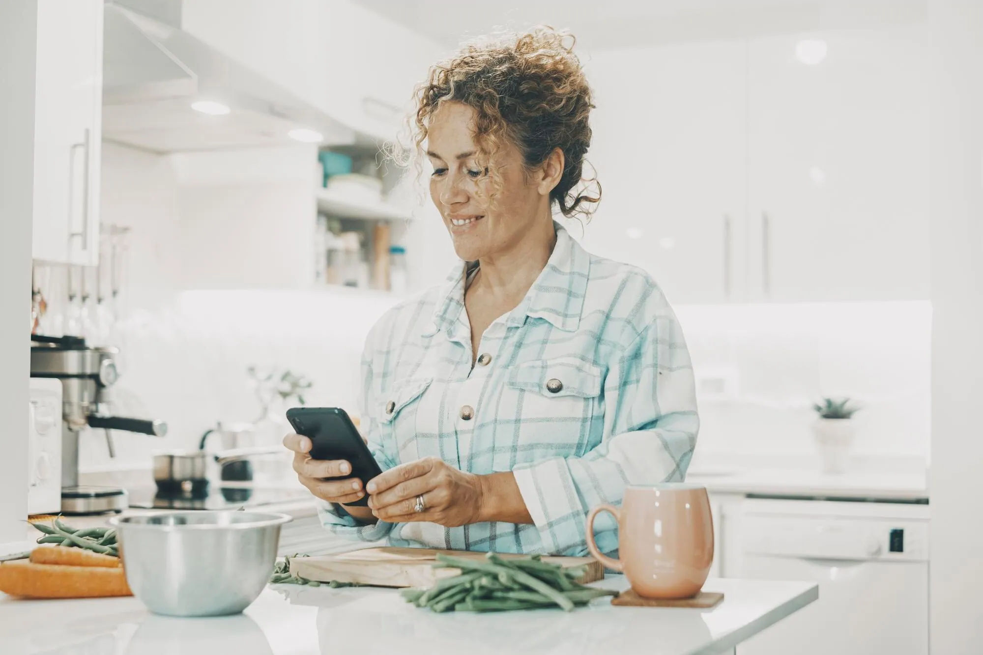 Home cook following a recipe on a phone in the kitchen