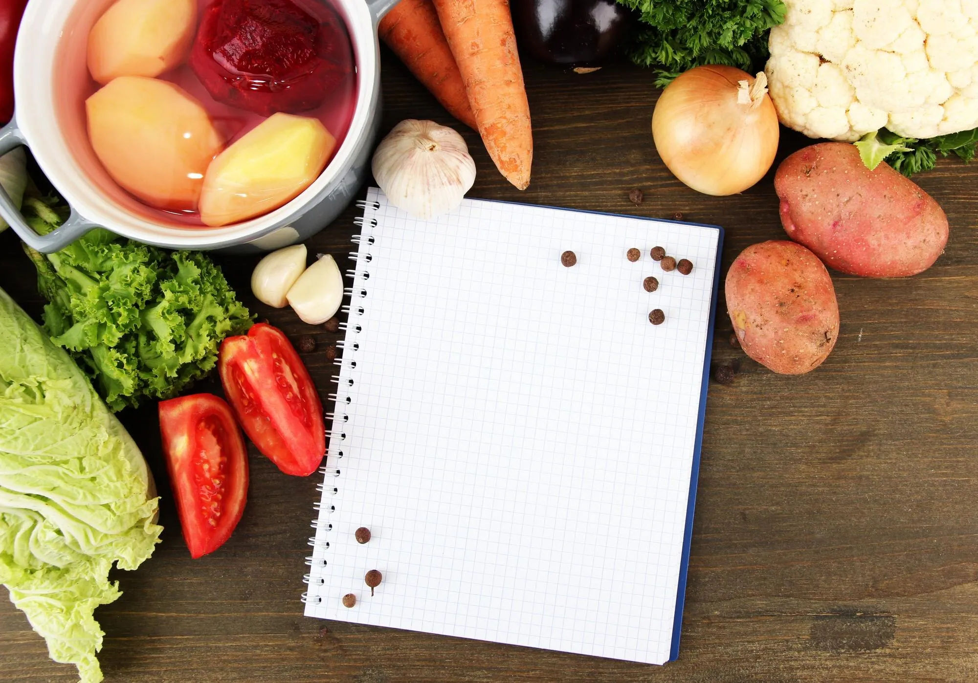 Ingredients surrounding a blank notebook for meal planning