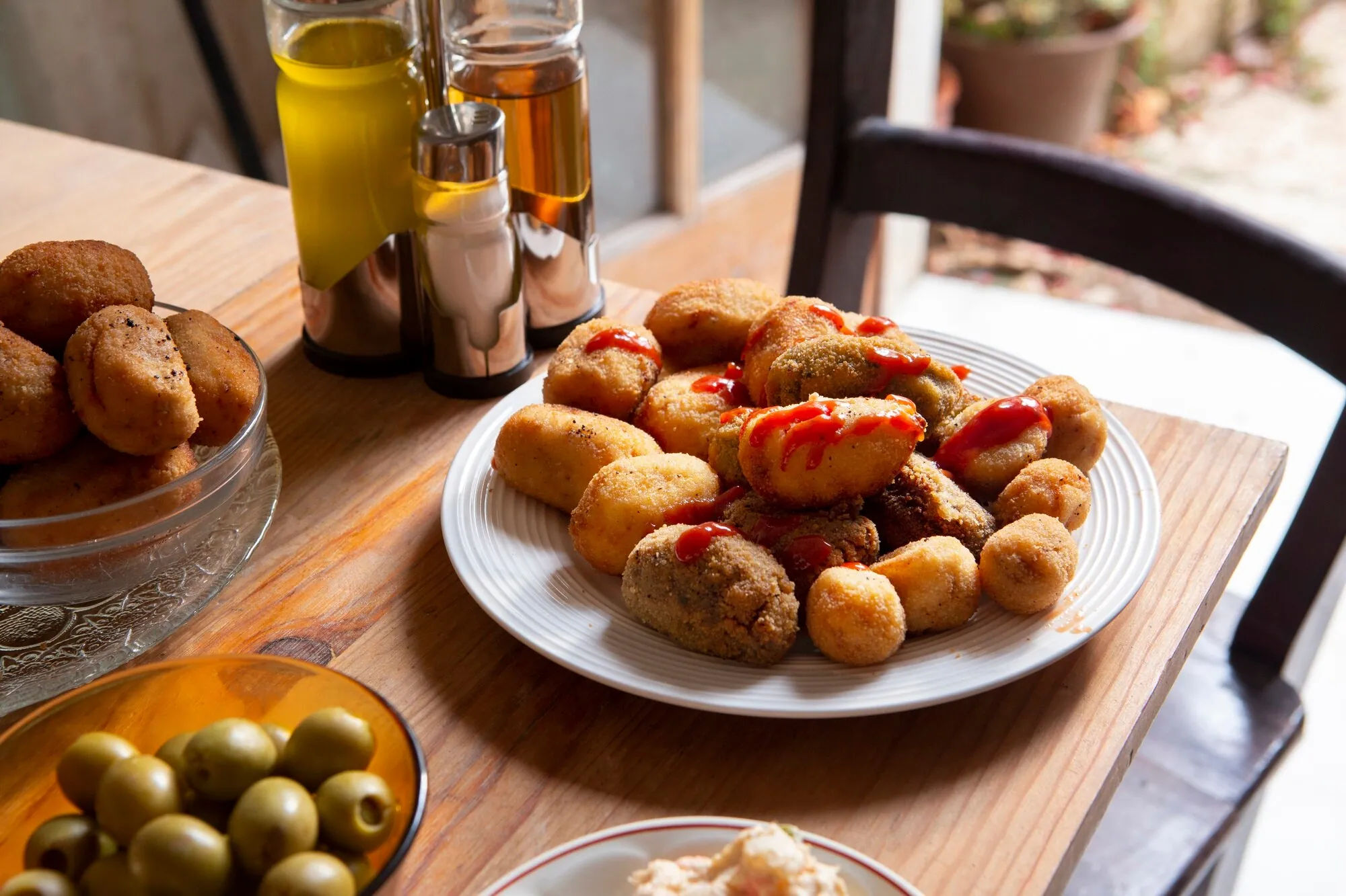 Kroketten und Oliven auf einem Tapas-Tisch
