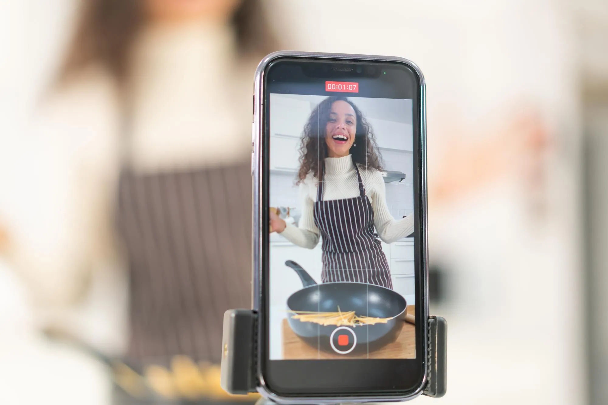 Smartphone recording a cooking video in a home kitchen