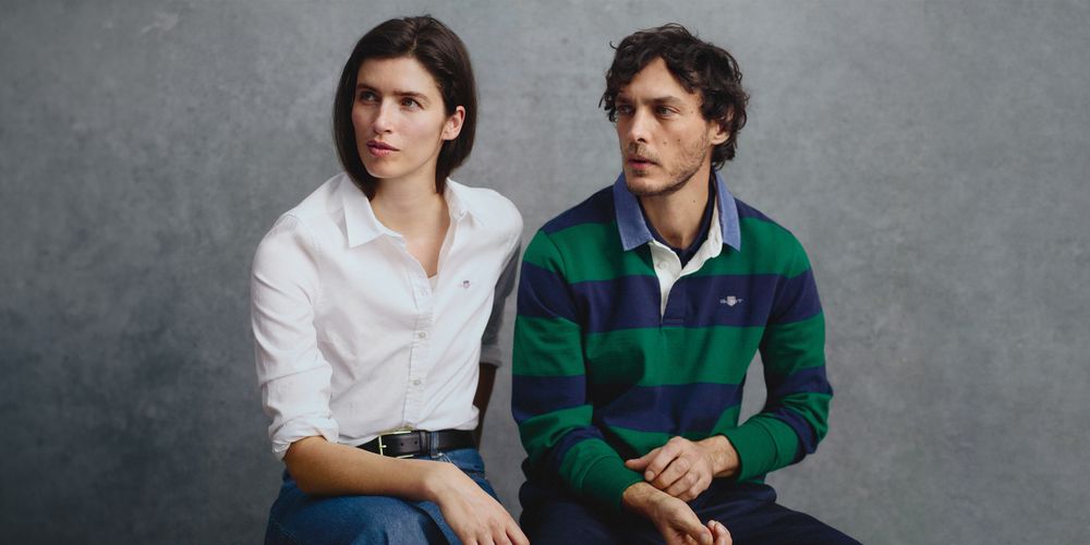 Man and woman wearing essential shirt and rugger
