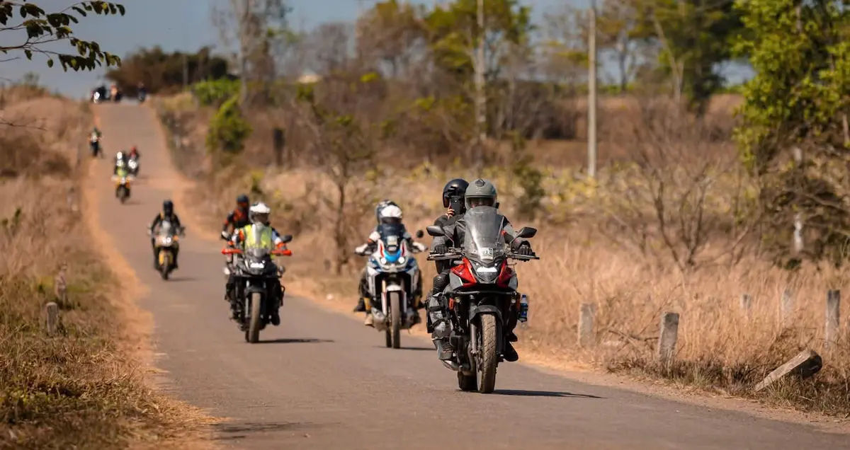 Ho Chi Minh Trail motorbike tour riders on a dirt trail between Pleiku and Yok Don national park, Vietnam cross country ride