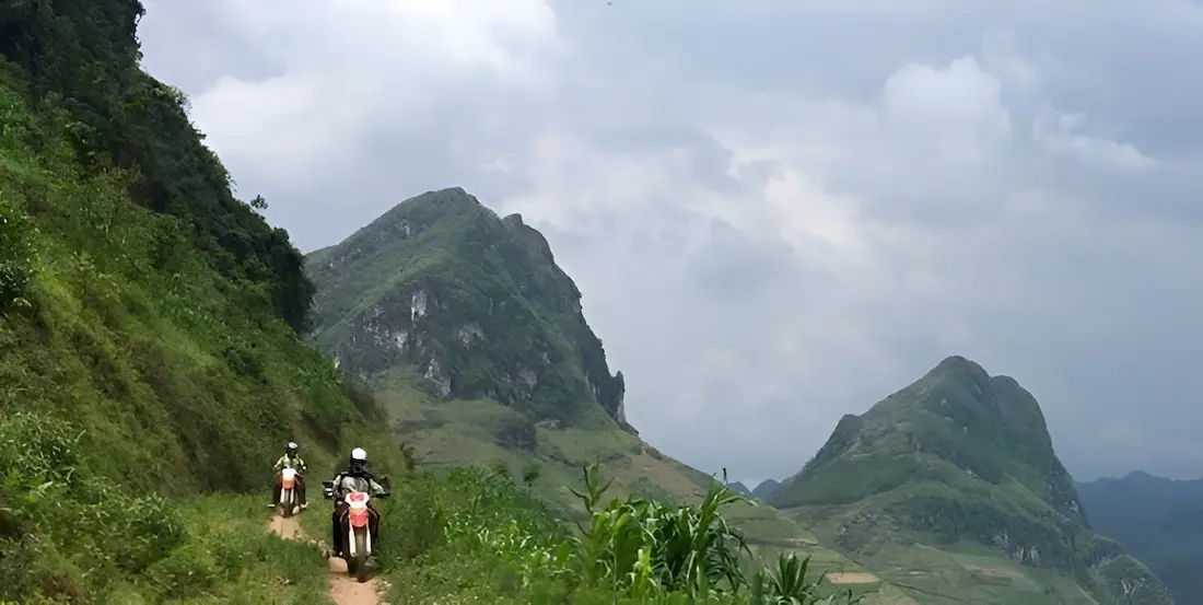 bikers riding a narrow dirt track in northwest vietnam with irtouring motorbike tours