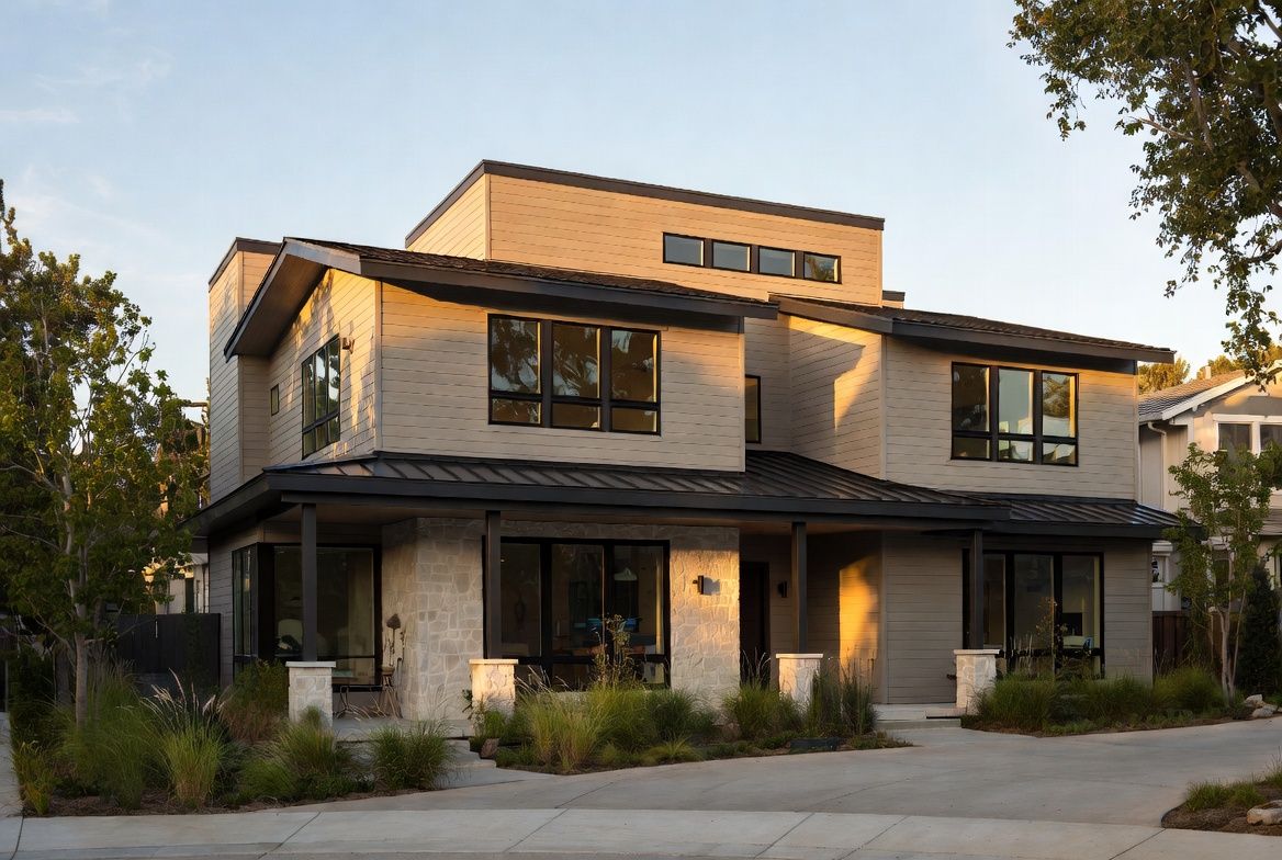 Photorealistic front elevation of The Halcyon Dwelling displaying modern architecture with light-gray cedar siding, limestone base, black metal details, and landscaped front yard.