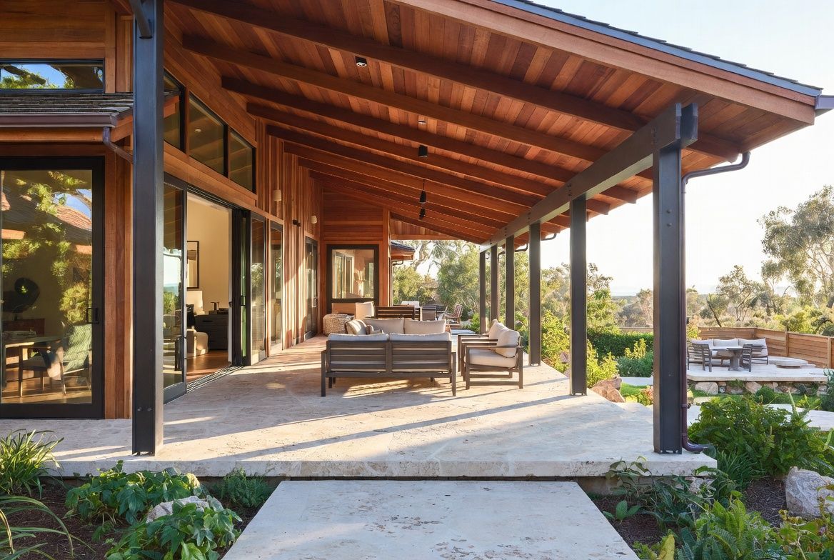 Photorealistic view of the veranda of The Halcyon Dwelling showing covered outdoor living space with cedar ceiling, limestone decking, and modern seating.